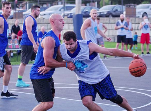Team Smalley wins summer basketball league Team Smalley's captain John Smalley moves the ball forward while covered by Team Tobin's, Mike Tobin.