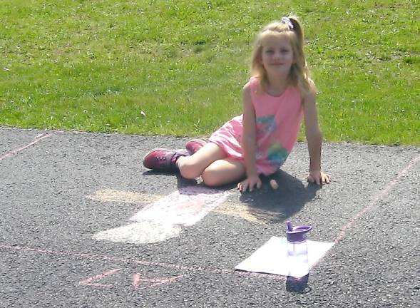 Lola Ball worked diligently on her sidewalk project (Photo by Janet Redyke)