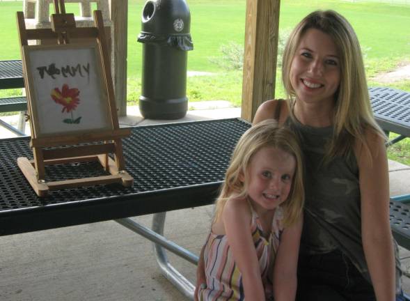 Lily, left, and her mom, Erin Ryan, pose with Lily&#x2019;s art dedicated to her mom.