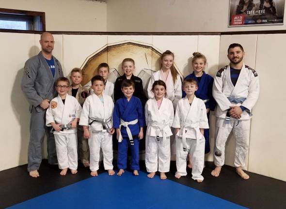 Promotions earned by 16 local youth martial artists Coaches Moe and Joe with some of the newly promoted students (Back, L-R: Maurice Johnson, Dexter Liddle, Mason Reed, Josh Enberg, Caitlin Frey, Kristin Frey, Joe Tizzano; Front, L-R: Anthony Reyes, Lincoln Andres, Connor Frey, Sophia DeNapoli, Nolan Reed)