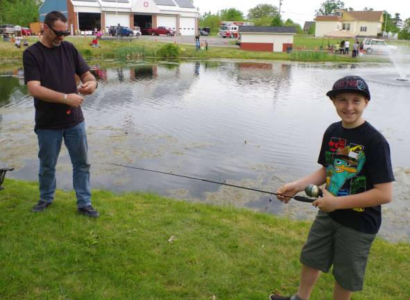Adam Dickenman, 11, of Vernon and his father, Marc, are regulars at the fishing derby. It is Adam&#xfe;&#xc4;&#xf4;s job to catch them and Marc&#xfe;&#xc4;&#xf4;s job to bait the hook and then gently remove it from the fish.