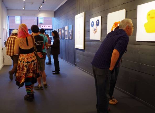 Visitors peruse the &#xfe;&#xc4;&#xfa;Supergood&#xfe;&#xc4;&#xf9; offerings of artists Johnny Moroz and Garret Torres.