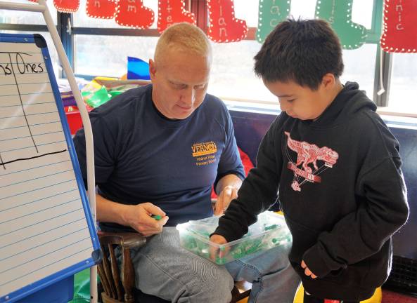 'Dedicated Dads' volunteer at Walnut Ridge Dedicated Dad Jake Hanson helps with special math blocks.
