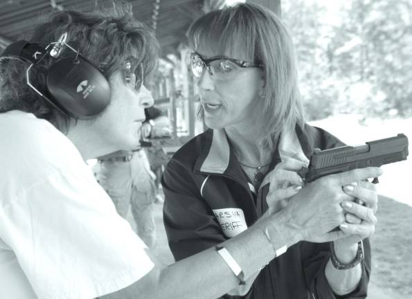 Cherry Ridge Range holds Family Day Nationally certified handgun instructor Marsha Sheriff of Sparta is shown teaching Highland Lakes native Joan Marri the finer points of firing a pistol.