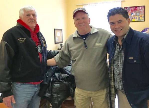 Sensei Tom Shull and Retired Lieutenant Gary Gardner of the Vernon Police Department present the clothing collected by the academy&#x2019;s students to Mario from The Alamo Farmworkers Community Center.