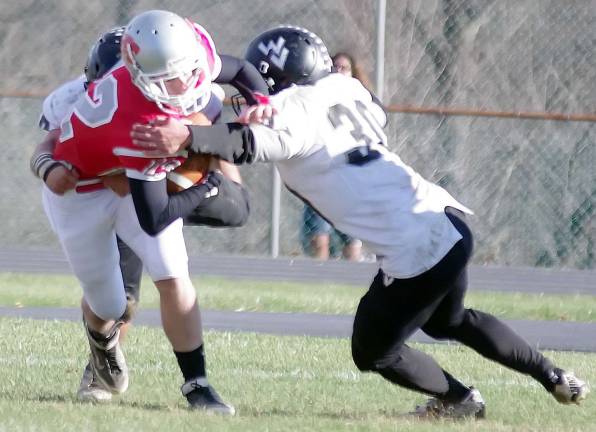 Wallkill Valley defenders grab a High Point ball carrier.