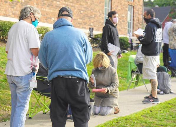 Just another day (and night) at the DMV A DMV employee helps someone in line (Photo by Vera Olinski)