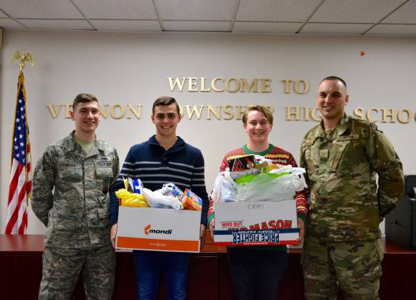 In the true spirit of the season, the guidance department at Vernon Township High School, under the leadership of Mrs. Donna Picciuto, ran a drive to collect personal care items, snacks and other goodies to send to Air Force troops deployed all over the world. Here, Staff Sergeant Jordan Sheldon (right) and A1C Trever Farber (left) show their gratitude as Caleb Gibson (center left) and Troy Livoti show them part of the donations for &#x201c;Operation Care Package.&#x201d;