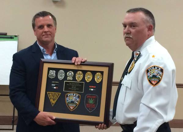 PHOTOS BY DIANA GOOVAERTS Vernon Police Chief Randy Mills presents retired Capt. Brian Jernick with a plaque commemorating his service.