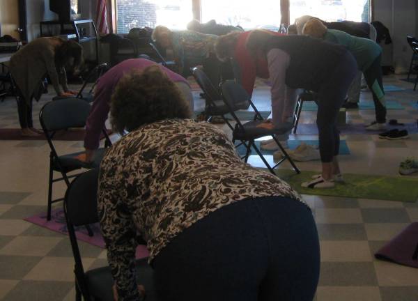 namaste, everyone Tabletops using a chair maintains a stress relieving stretch.