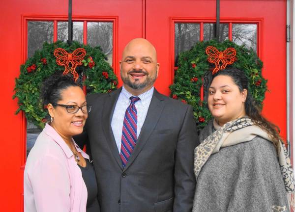 From left, Jackie, Pastor Michael, and Samantha Rojas stand in front of the new doors.