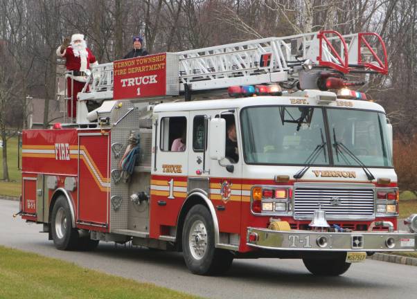 PHOTO BY MARK LICHTENWALNER Santa Claus mae his annual visit to Vernon Township, haning out candy canes to children.