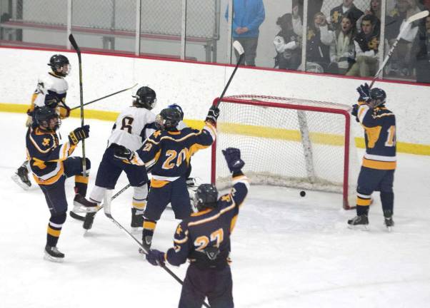 The Jefferson Falcons raise their sticks in celebration after scoring a goal.