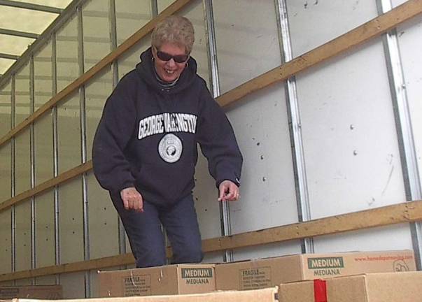 Jill Passaretti, president of the NJ State Federation of Woman&#x2019;s Clubs and a member of the Vernon Township Woman&#x2019;s Club, moves cartons containing 974 Christmas stockings from a storage container to a truck.&#xa0;