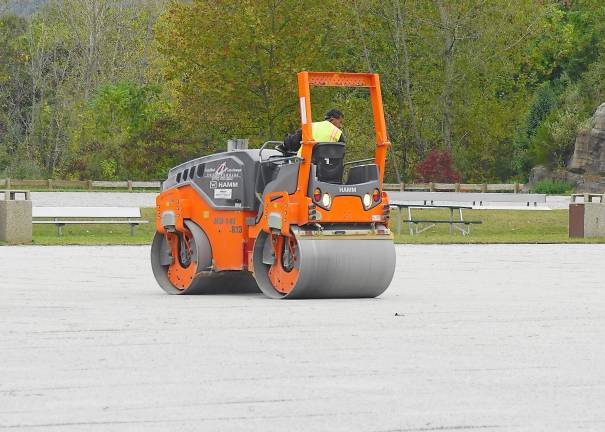 A worker smooths one of the two upper fields of Maple Grange