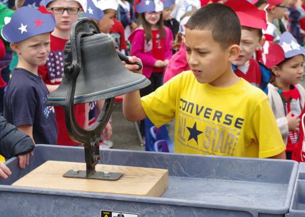 Walnut Ridge students offer patriotic songs for veterans and family members Youngsters took turns ringing the bell following the Pledge of Allegiance.