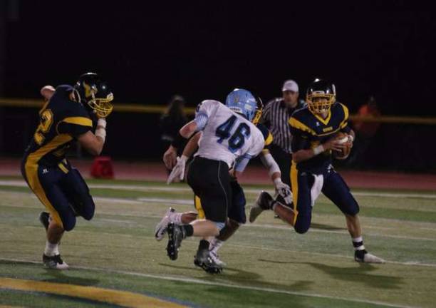 Vernon's quarterback Tyler Soltes rolls out with the ball.