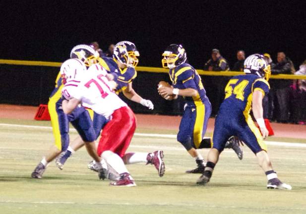 Vernon quarterback Brandon Lavorini on the run with the ball as the offensive line holds back the Morris Hills defense.