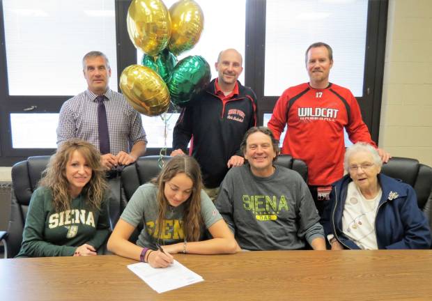 Margo Peterson, seated, signs her National Letter of Intent to continue her basketball career at Siena College next year. Pictured seated are (left to right) - mother Emma, Margo, father Dave, and grandmother Marlene. Standing (left to right) - Athletic Director Todd Van Orden, Head Coach Chris Dexter, and Principal Jon Tallamy.