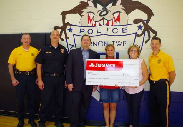 From the left are Vernon Township Police Department Cpl. Scott Waleck, Lt. Daniel B. Young, local agent Kyle Hamer and public affairs specialist Jen Young of State Farm Insurance, PAL assistant director Jeanne Buffalino, and Sgt. Jason Haw.