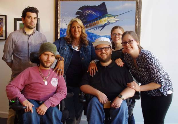 In the casual setting of Art Etc. are from left, gallery owner Marshall Okin, Anthony D'Agostino, his mother Susan D'Agostino, poet and author Nicholas D'Agostino, friend and gallery worker Rachael Klein, and Nicholas' girlfriend Breelagh DuHaime. Behind them is a painting by Mark Mueller of Ogdensburg.
