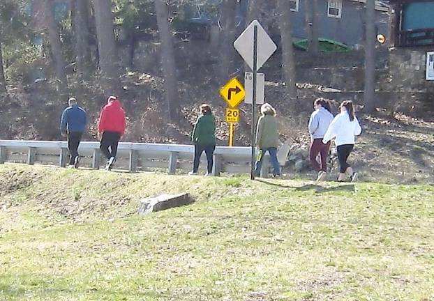 During the Covid-19 crisis, friends hike on Breakneck Road observing distance between.