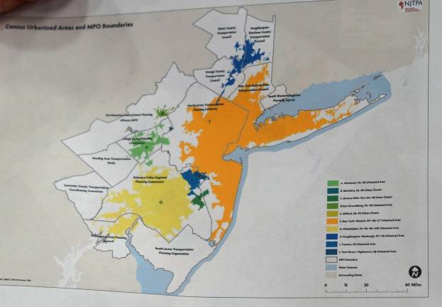Freeholder Richard A. Vohden holds a map of the proposed transportation planning regulation changes. The proposed N.Y. Metropolitan Planning Area is shaded in orange.