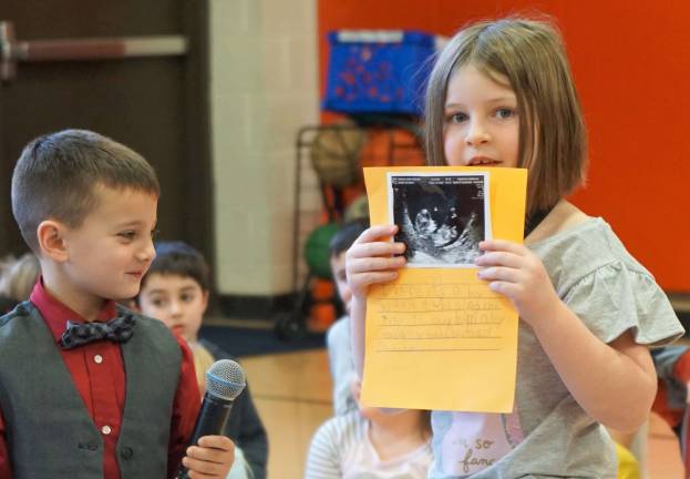 From right, Carli shows her sibling's sonogram, as Frankie looks on left.