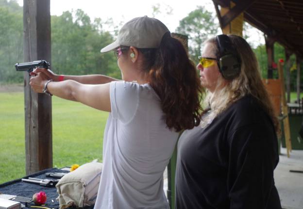A female student fires a 9 mm Beretta under the watchful eye of her instructor, Diane Alexander, at Cherry Ridge Range&#xfe;&#xc4;&#xf4;s annual Family Day at the Range last Saturday.