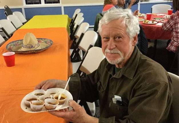 Gary Cucci with a plate full of sample chili's