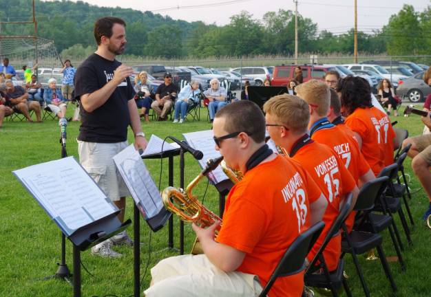 Taylor is shown conducting the Vernon Township High School Jazz Express. They were the second act to perform that evening and were announced by the horns of a four-locomotive freight train across the field from the Flats.
