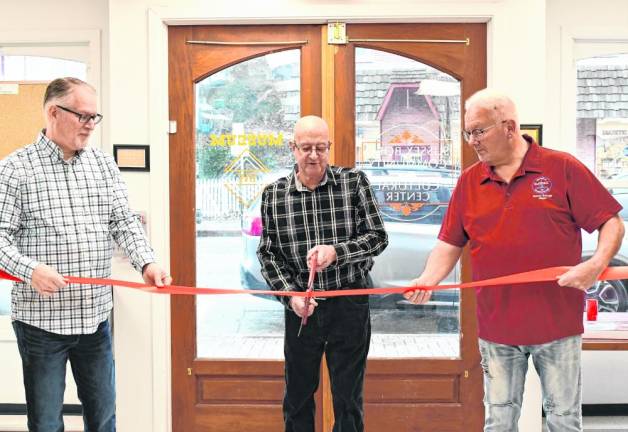Mario Poggi, Sussex Borough’s historian, cuts the ribbon at the opening of the Sussex-Wantage Historical Society Museum on Saturday, March 2. With him are Wantage Mayor William Gaechter, left, and Sussex Mayor Robert Holowach.