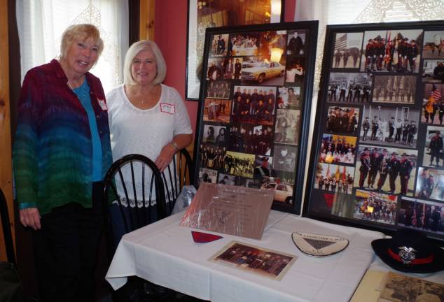Event organizers Carol Schroeder and Pat Wootton stand by a large collection of old photos and memorabilia collected and arranged by retired Captain Stephen Moran. Schroeder was the department's first secretary.