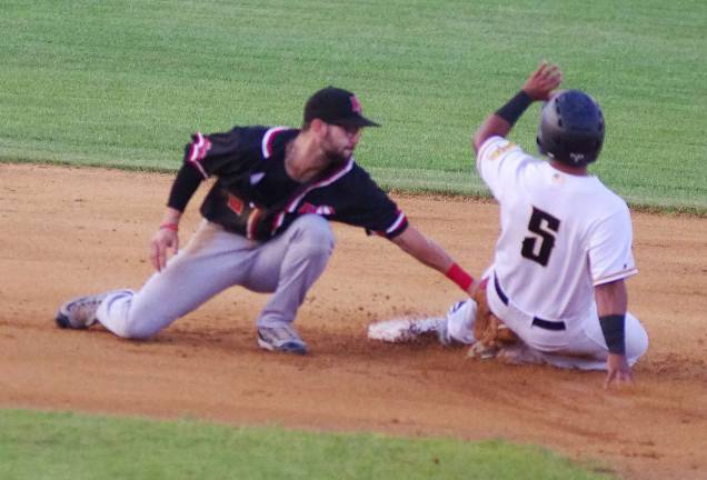 Jackals infielder Rylan Sandoval's tag is too late as Miners runner Alexi Colon slides safe onto second base in the first inning.