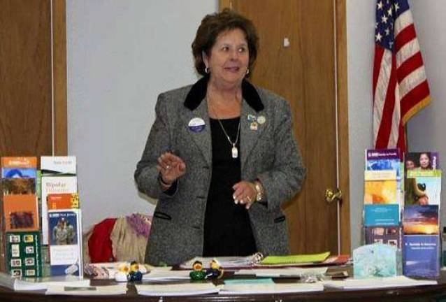 Surrounded by a wealth of materials about services for families and individuals affected by mental illness, Marjorie Strohsahl from the New Jersey State Federation of Women's Clubs speaks to the GFWC Vernon Township Woman's Club about the National Alliance on Mental Illness.
