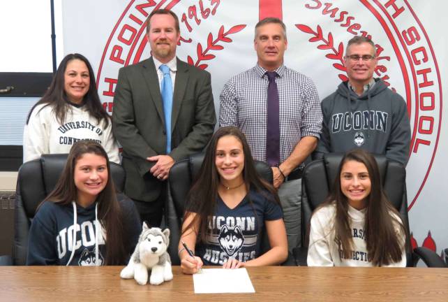 High Point's Jackie Harnett, seated center, signs her National Letter of Intent to continue her soccer career at the University of Connecticut. Pictured are: Seated from left to right: Victoria Harnett - sister, Jackie Harnett, and Sarah Harnett - sister. Standing from left to right: Carole Harnett - mother, Principal Jon Tallamy, Director of Athletics Todd Van Orden, and Anthony Harnett - father.