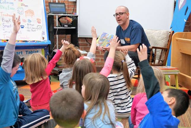 Enthusiastic Kindergartners respond as Dedicated Dad Gene Arnold reads a book to them.