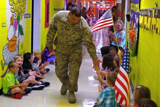 Army Sergeant First Class Roland Tajalle received many high-fives from the students as he walked down the hall of Walnut Ridge Primary School.