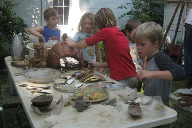 PHOTOS BY JANET REDYKEYoungsters work on artifacts discovered at the yearly archaeological dig at camp held at Fields of Green School.