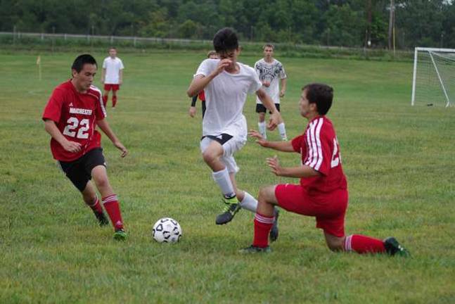 Sussex Tech Mustangs practice for season A Sussex County Tech Mustang between two Manchester Falcons.