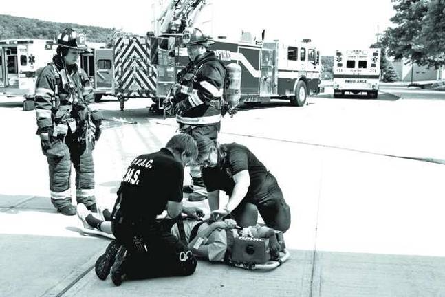 An &#x201c;injured&#x201d; student is shown being evacuated from the high school following a chemistry lab explosion and subsequent fire at the high school.