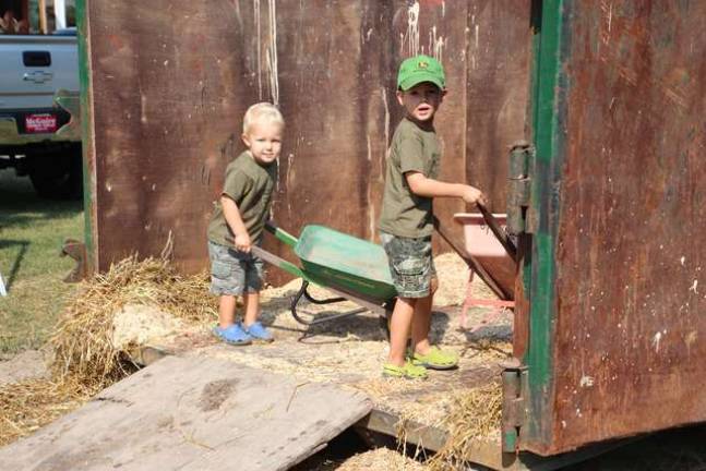 Everyone in the family pitches in. By Acre Farms in Wantage have Asa and Asher Tolar help clean out the barn.