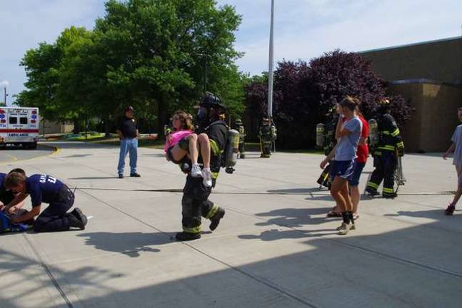 An &#x201c;injured&#x201d; student is shown being evacuated from the high school following a chemistry lab explosion and subsequent fire at the high school.