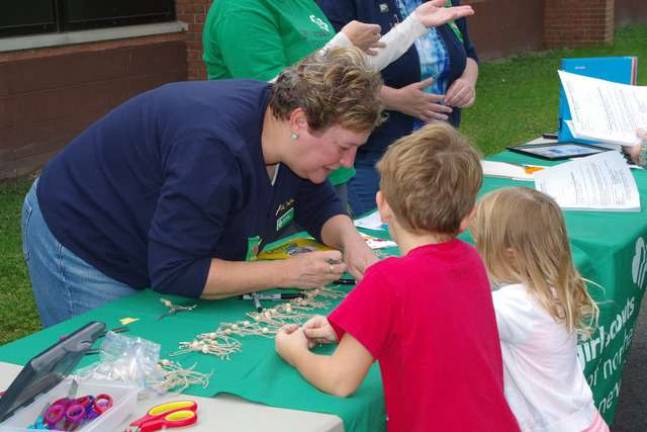 Vernon Girl Scout recruiter Leslie Glick helps visiting children create crafts at the Girl Scouts table during the Walnut Ridge School&#x2019;s Fall Harvest Breakfast.