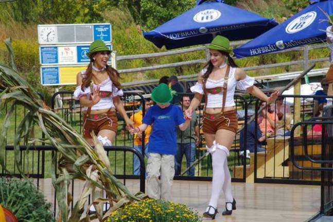 Bavarian-style go-go dancers escort a young guest to the dance floor.