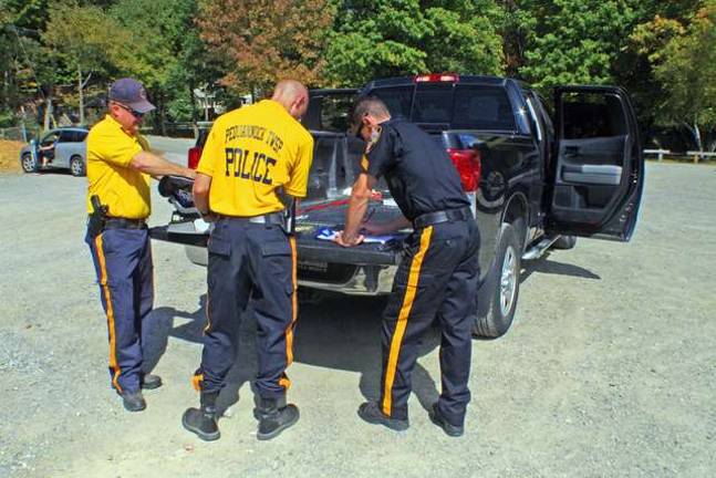 At right, Vernon Township Police Sergeant Jason Haw is shown making detailed reports of how the child safety seats were installed when they arrived for inspection and the necessary steps, if needed, to correct or improve the installations.