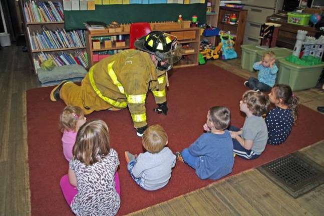 Never too young to learn about fire safety Vernon Valley Lake resident and Allendale Volunteer Fireman Bob Winter is shown teaching preschool students about fire safety and the gear that firefighters wear.
