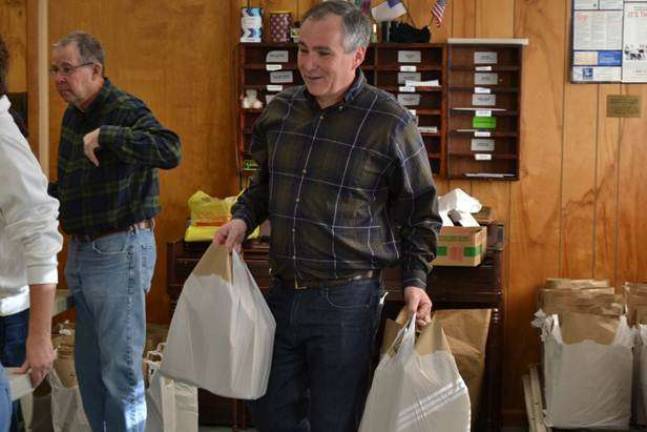 Commissioner Harold J. Wirths of the New Jersey Department of Labor and Workforce Development helps volunteers at the Sussex United Methodist Church organize and bag complete Thanksgiving dinners to be distributed to needy families throughout Sussex County.