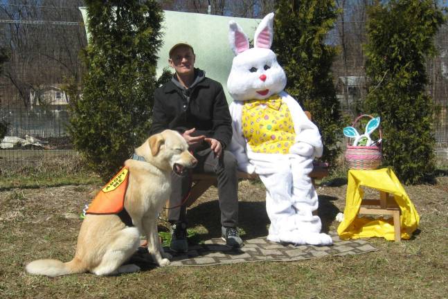 The Easter Bunny posed for holiday photos. In the view finder is foster owner James Heineman and retriever/husky mix Dagger, who is currently available for adoption through The 11th Hour Rescue.