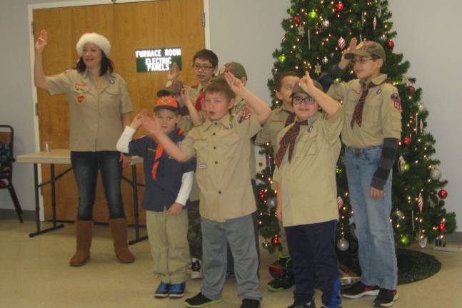 With the three- finger scout salute, Cub Scout Pack 404 and Boy Scout Troop 912 recite the pledge to an audience at the Vernon Senior Center.